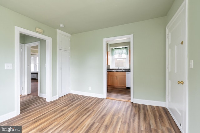 empty room with hardwood / wood-style floors and sink