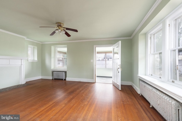 spare room featuring ceiling fan, radiator heating unit, and dark hardwood / wood-style flooring