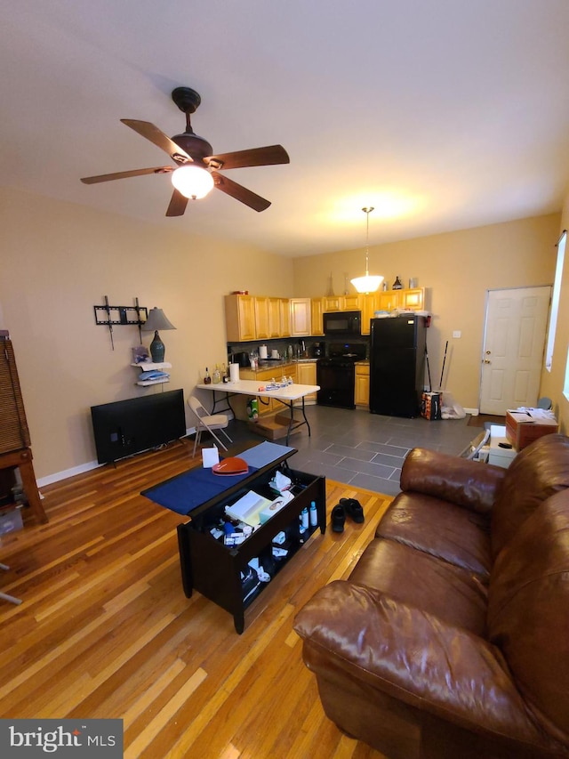 living room with ceiling fan and light wood-type flooring