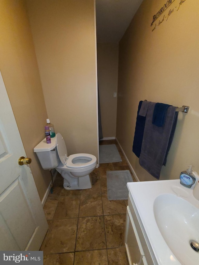 bathroom featuring toilet, tile flooring, and vanity