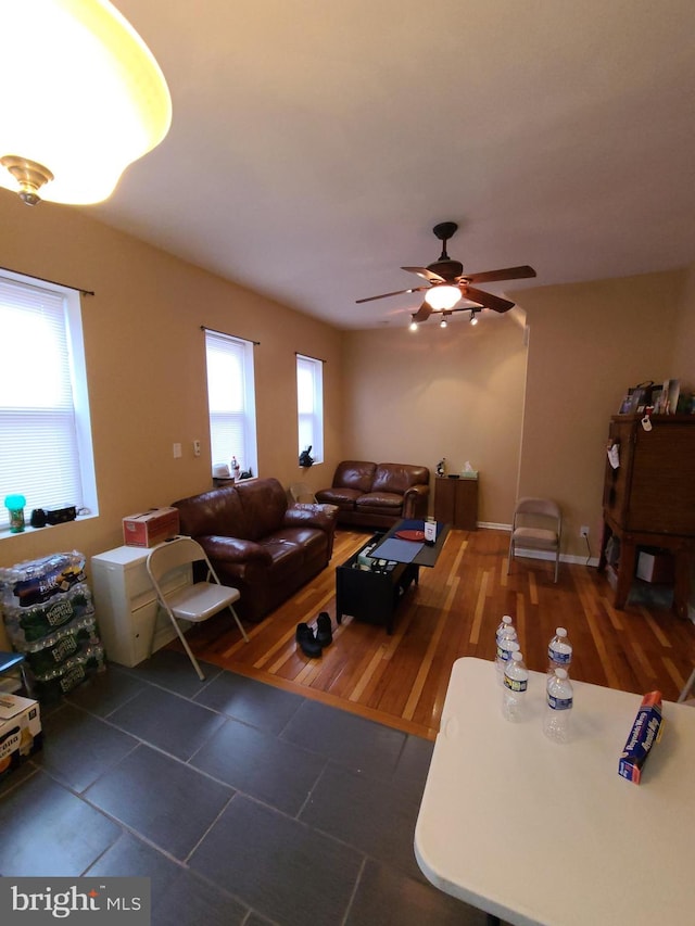 living room featuring dark wood-type flooring and ceiling fan