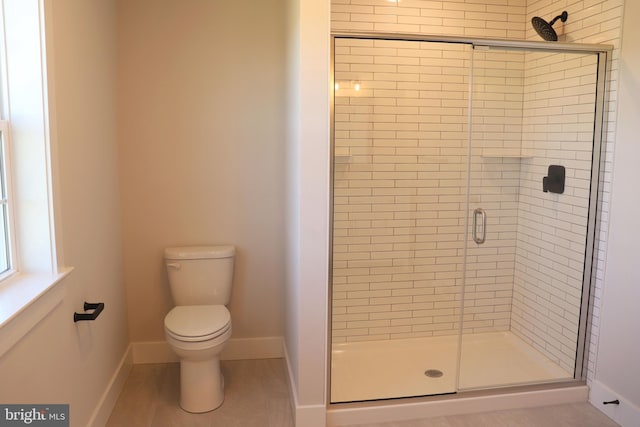 bathroom featuring toilet and an enclosed shower