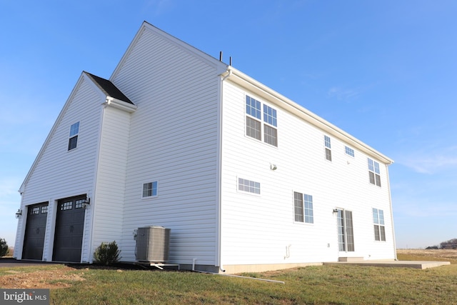 back of house with a yard and a garage