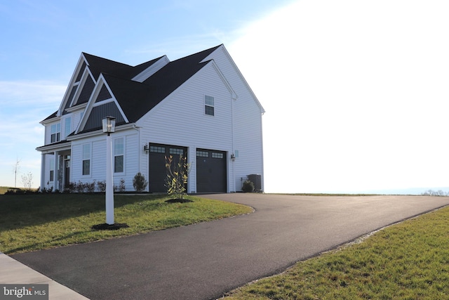 view of side of home featuring a lawn and a garage