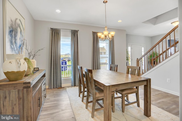 dining area featuring light wood-type flooring and an inviting chandelier