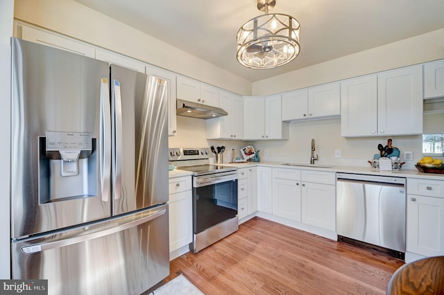 kitchen featuring sink, white cabinets, appliances with stainless steel finishes, light hardwood / wood-style flooring, and an inviting chandelier