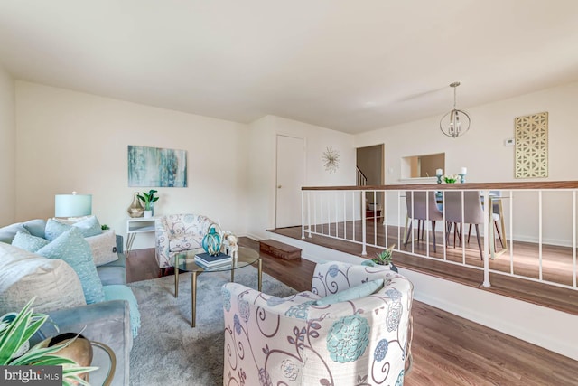 living room featuring a notable chandelier and dark wood-type flooring