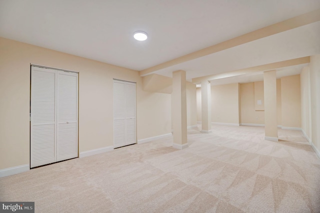 unfurnished bedroom featuring light colored carpet and multiple closets