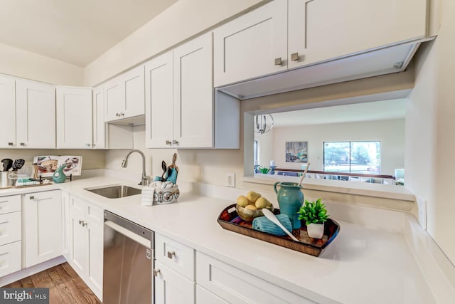 kitchen featuring white cabinets, stainless steel dishwasher, light hardwood / wood-style floors, and sink