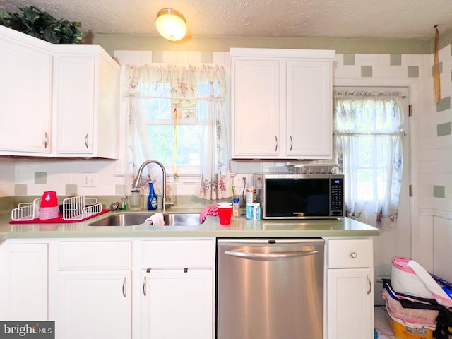 kitchen featuring tasteful backsplash, white cabinetry, appliances with stainless steel finishes, and sink