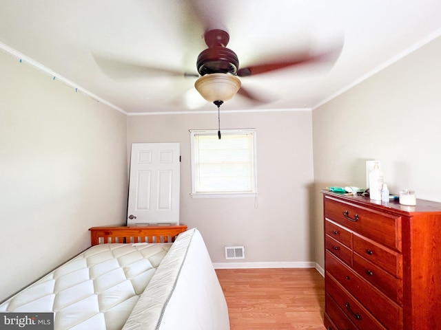 bedroom featuring crown molding, light hardwood / wood-style floors, and ceiling fan