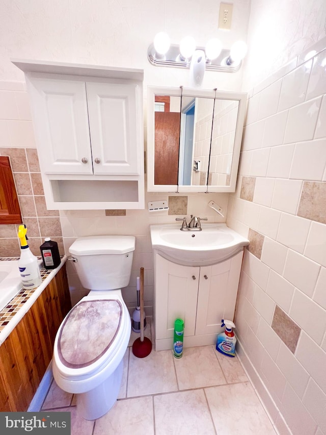 bathroom featuring tile walls, toilet, tile floors, and vanity with extensive cabinet space