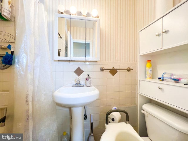 bathroom with toilet, tasteful backsplash, and tile walls