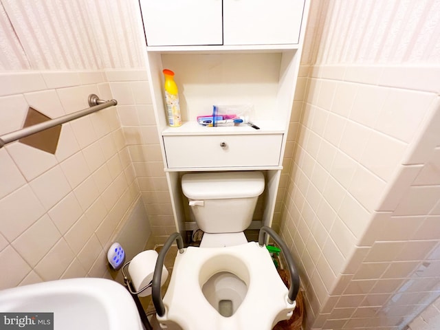 bathroom featuring tile walls and toilet