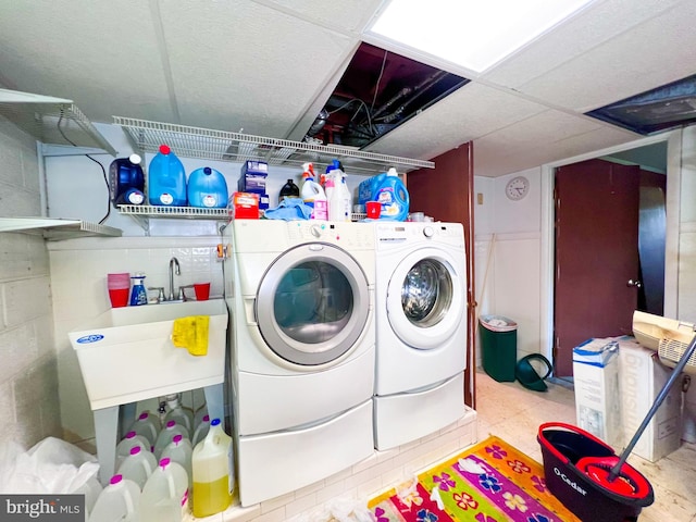 laundry room with sink, light tile floors, and washing machine and dryer