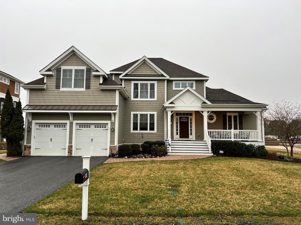 view of front of house with a porch, a garage, and a front yard