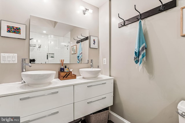 bathroom with toilet and dual bowl vanity