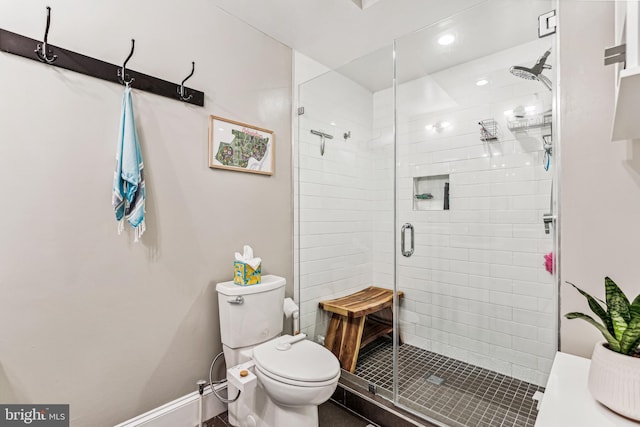 bathroom with a shower with door and toilet