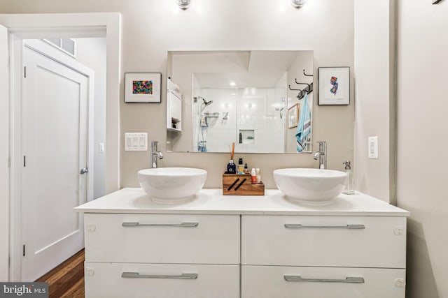 bathroom with double vanity and hardwood / wood-style flooring