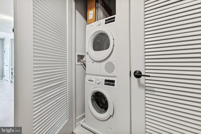 clothes washing area with washer hookup and stacked washing maching and dryer