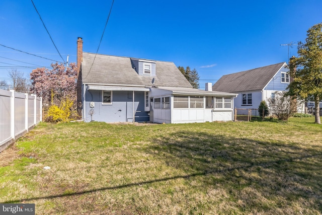 back of house with a sunroom and a lawn