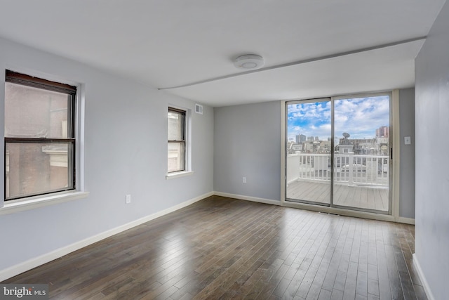 empty room with dark hardwood / wood-style flooring