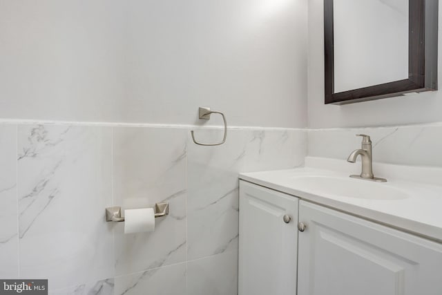 bathroom featuring vanity and tile walls