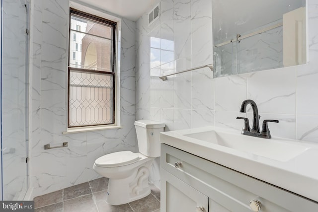 bathroom with tile walls, tile floors, toilet, and oversized vanity