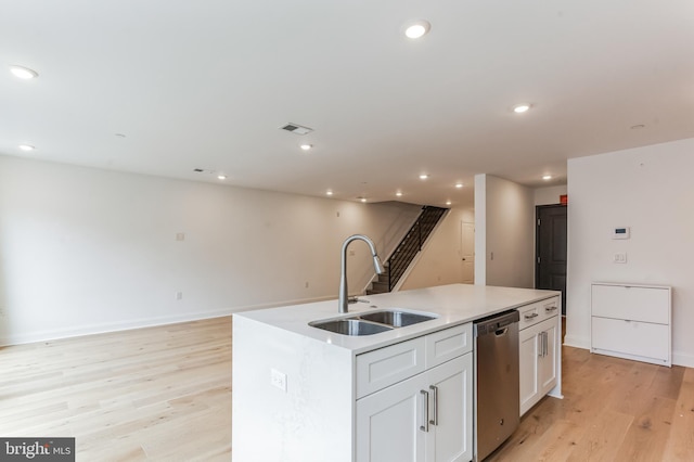 kitchen with white cabinetry, light hardwood / wood-style flooring, a kitchen island with sink, dishwasher, and sink