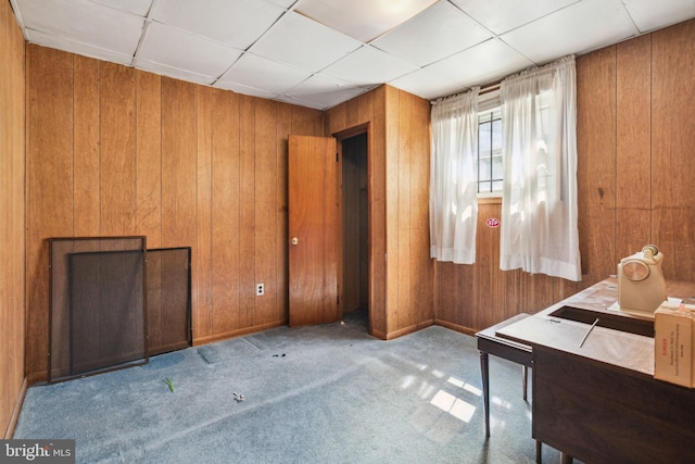 miscellaneous room featuring wooden walls, light colored carpet, and a drop ceiling