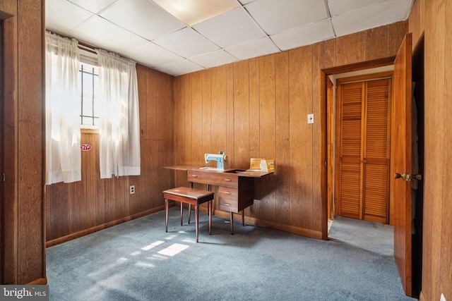 miscellaneous room with wooden walls, carpet flooring, and a paneled ceiling