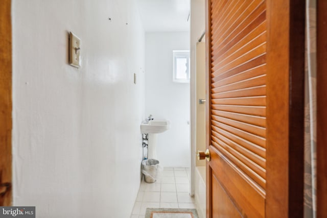 corridor featuring light tile floors and sink