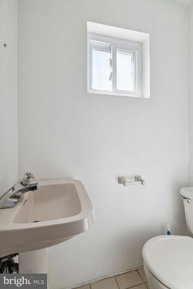 bathroom featuring tile flooring and toilet