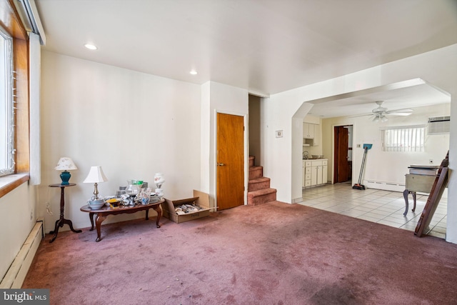 miscellaneous room with light carpet, a wall mounted air conditioner, ceiling fan, and a baseboard heating unit