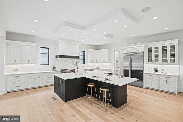 kitchen with a large island with sink, white cabinetry, appliances with stainless steel finishes, and a kitchen breakfast bar