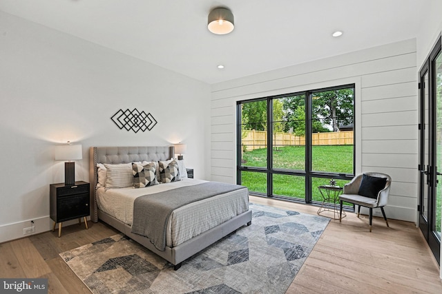 bedroom with hardwood / wood-style floors and wood walls