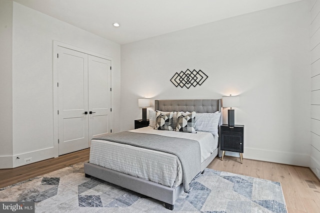 bedroom with hardwood / wood-style floors and a closet