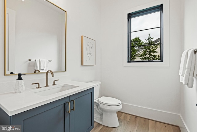 bathroom with hardwood / wood-style flooring, vanity, and toilet