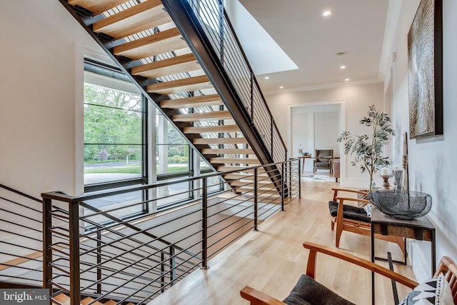 stairway featuring ornamental molding and hardwood / wood-style flooring