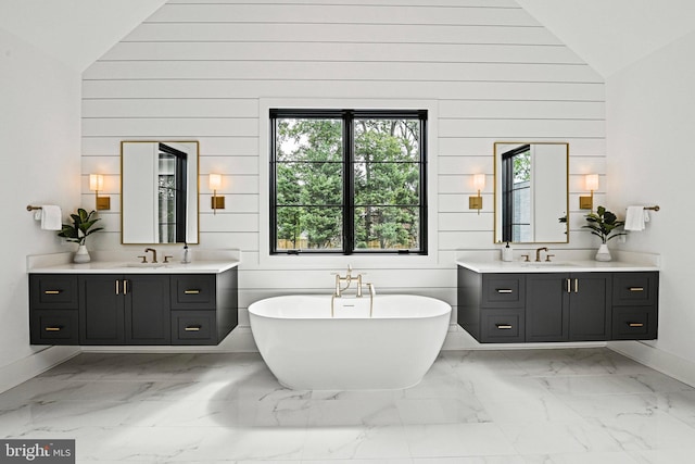 bathroom featuring vanity, wooden walls, high vaulted ceiling, and a bathing tub