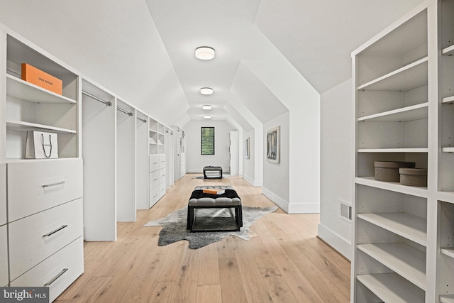 spacious closet featuring lofted ceiling and light wood-type flooring