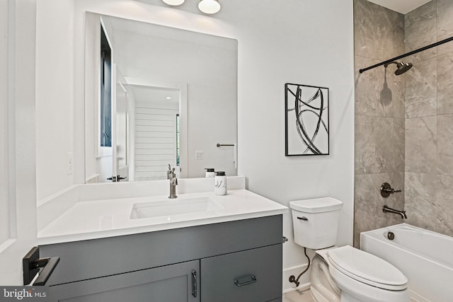 full bathroom featuring tiled shower / bath, vanity, and toilet