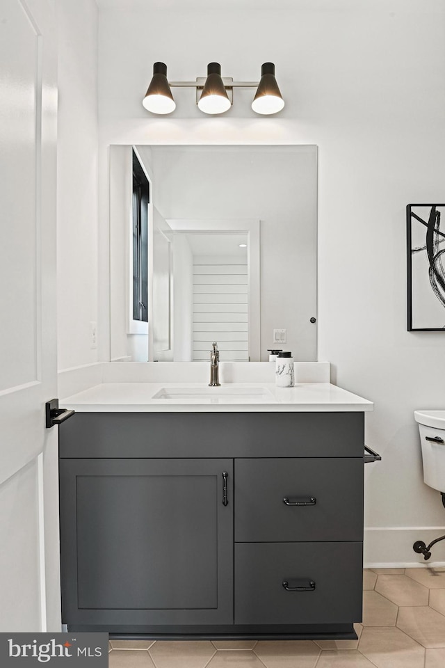 bathroom featuring tile patterned floors, vanity, and toilet