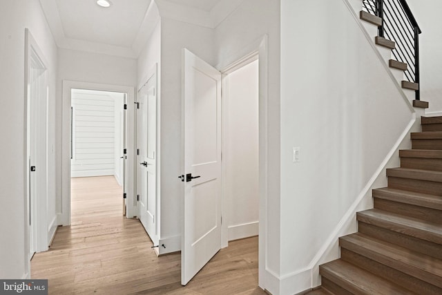 stairway with hardwood / wood-style floors and crown molding