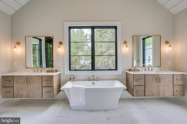 bathroom featuring vanity, a bath, and high vaulted ceiling