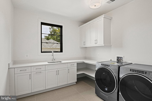 laundry room with washer and dryer, light tile patterned flooring, sink, and cabinets