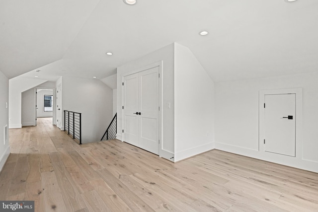 bonus room featuring vaulted ceiling and light wood-type flooring