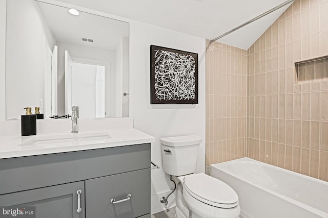 full bathroom featuring tiled shower / bath combo, vanity, lofted ceiling, and toilet