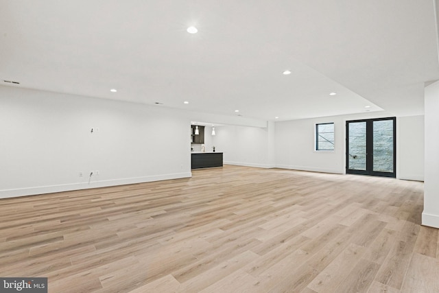 unfurnished living room with french doors and light hardwood / wood-style floors