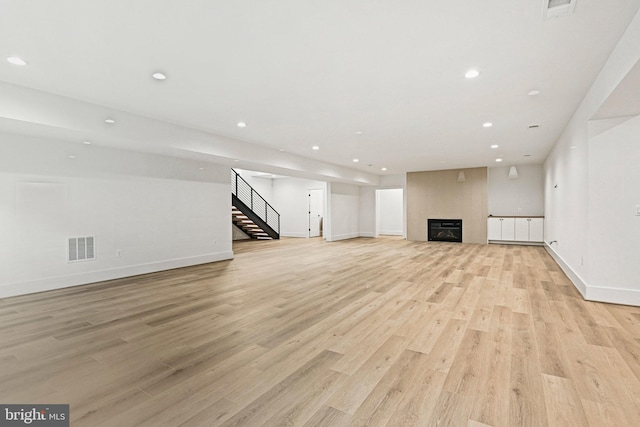 unfurnished living room with a fireplace and light hardwood / wood-style floors